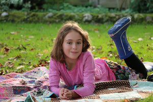 little girl laid on handmade liberty fabric quilts as a boho picnic blanket